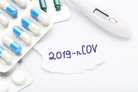 Text 2019-nCov with pills and thermometer on white backgroundの写真素材