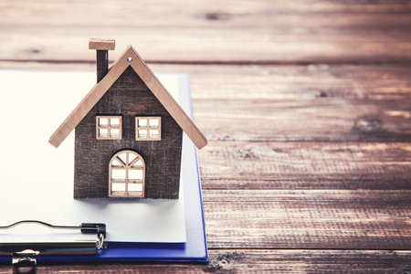 House model with clipboard on brown wooden tableの写真素材