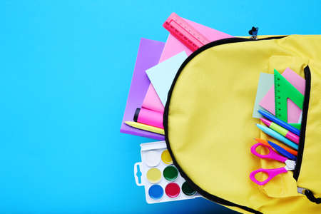 Backpack with school supplies on blue backgroundの写真素材