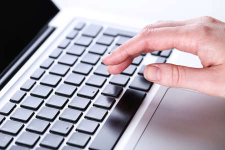 Female hand typing on laptop keyboard