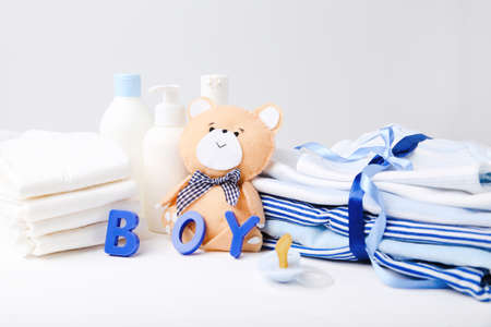 Folded baby clothes with diapers, soother and soft bear toyの写真素材