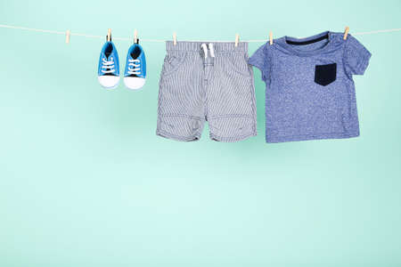 Baby clothes hanging on blue backgroundの写真素材