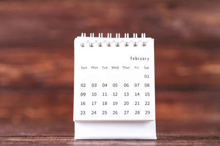 Paper calendar page on brown wooden backgroundの写真素材
