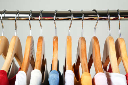 Wooden hangers with clothes on gray background