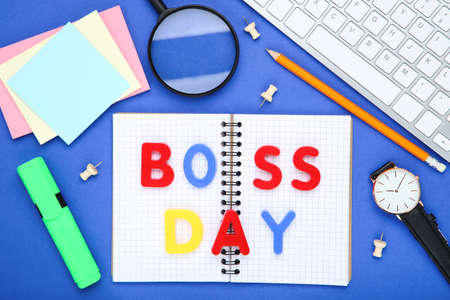 Colorful inscription Boss Day with stickers, keypad and notepad on blue backgroundの写真素材