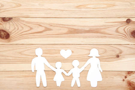 Family figures with heart on brown wooden tableの写真素材