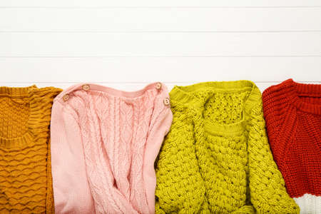 Colorful woolen sweaters on white wooden tableの写真素材