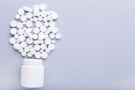 Medicine pills and bottle on gray background