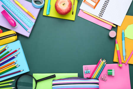 Different school supplies on chalkboard background