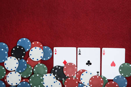 Poker chips and cards on red table