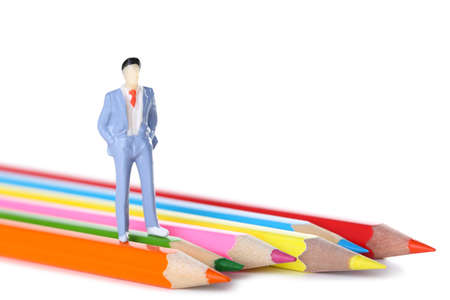 Miniature people with colorful crayons on white backgroundの写真素材