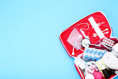 First aid kit with medical supplies on blue backgroundの写真素材