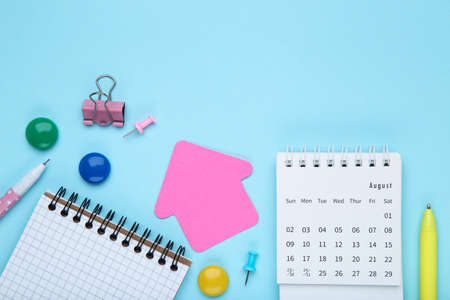 Calendar page with notepad and pens on blue backgroundの写真素材