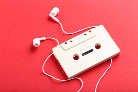 Earphones and cassette tape on red backgroundの写真素材