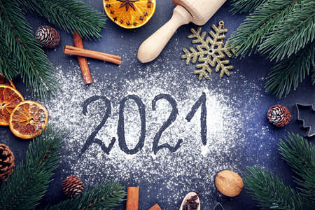 Inscription 2021 on wheat flour background with fir-tree branchesの写真素材