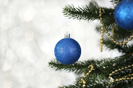 Christmas fir tree with ornaments on blurred lights backgroundの写真素材