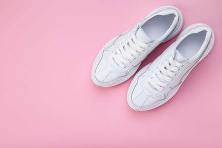 Pair of white shoes on pink backgroundの写真素材