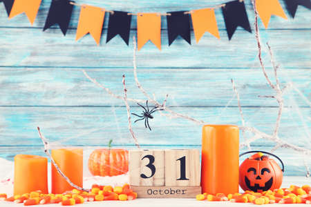 Halloween candies with candles, calendar, spider and paper flags on blue backgroundの写真素材