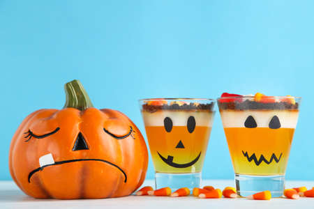 Halloween jelly in glasses with candies and pumpkin on blue backgroundの写真素材