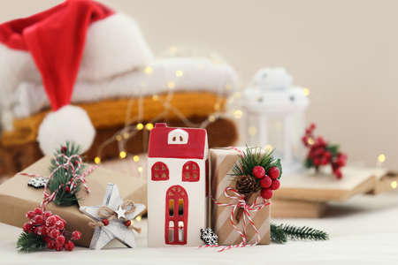 Christmas gift boxes with fir tree branches, decorative home, folded sweaters and santa hat