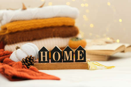 Text Home with pumpkins, books and folded sweaters