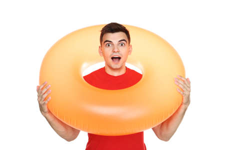 Young man with inflatable ring on white background