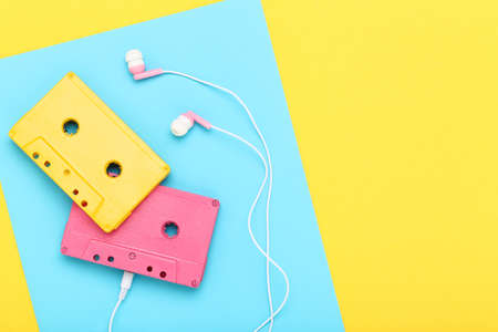 Earphones and cassette tapes on colorful backgroundの写真素材