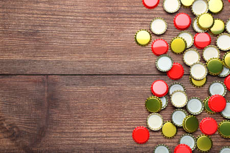 Colorful bottle caps on brown wooden tableの写真素材