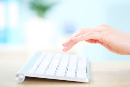 Female hand typing on computer keyboard