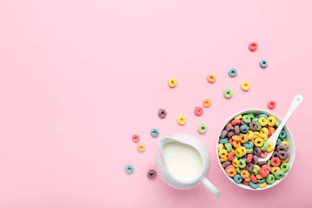 Colorful corn rings with milk in jar and spoon on pink backgroundの写真素材