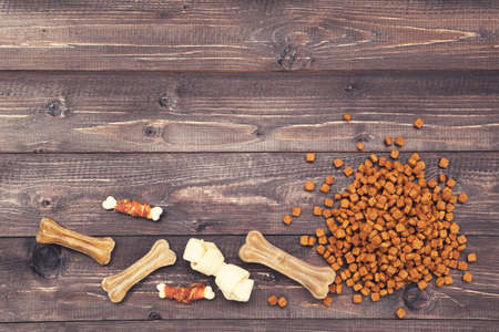 Dry pet food with bones on brown wooden tableの写真素材