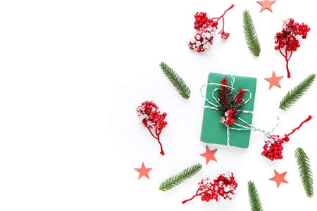 Christmas ornaments with red berries and gift box on white background