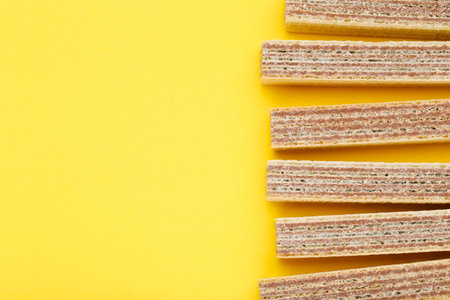 Sweet wafer sticks on yellow background