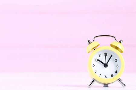 Yellow alarm clock on pink backgroundの写真素材