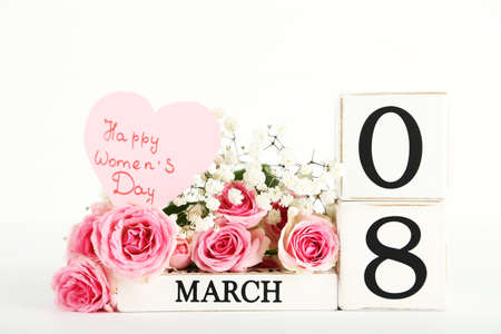 Cube calendar with bouquet of flowers and text Happy Womens Day isolated on white background