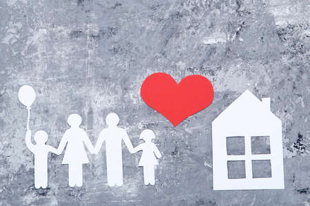 Family and house figures with red heart on gray backgroundの写真素材