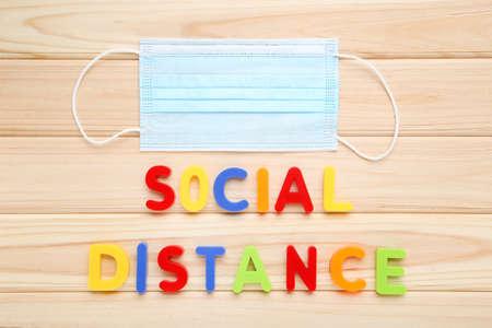 Medicine mask and inscription Social Distance on wooden backgroundの写真素材