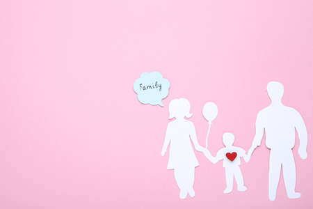 Family figures with red heart and speech bubble on pink backgroundの写真素材