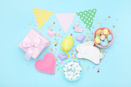 Easter gingerbread cookie with colorful eggs, paper flags, fabric heart and gift box on blue...