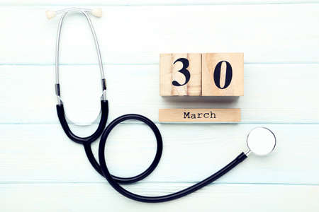 Stethoscope with cube calendar on white wooden tableの写真素材