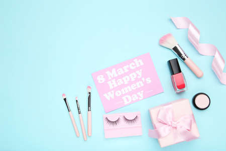 Card with text 8 March Happy Womens Day, gift box and makeup cosmetics on blue backgroundの写真素材