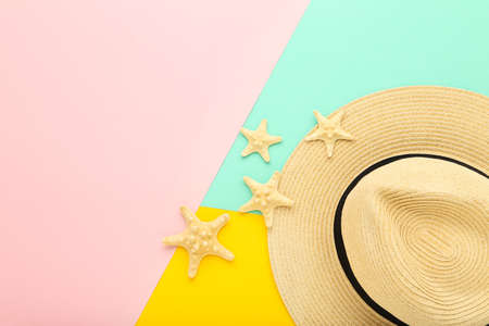 Summer straw hat with starfishes on colorful paper backgroundの写真素材