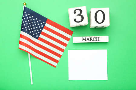 Text Doctor's Day with cube calendar and american flag on green backgroundの写真素材