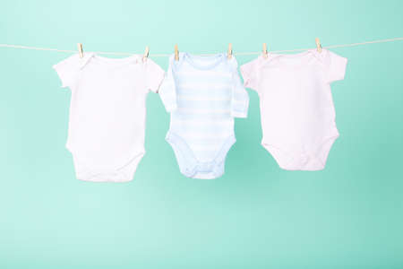 Baby clothes hanging on blue background