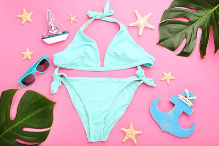 Fashion swimsuit with monstera leafs, sunglasses and starfishes on pink backgroundの写真素材