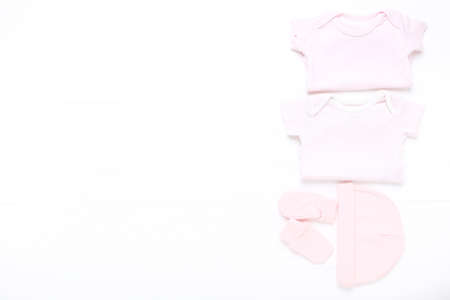 Baby clothes on white wooden tableの写真素材