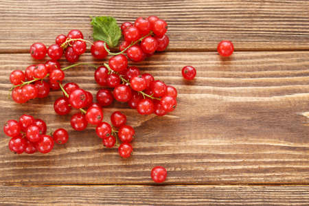 Red currants on brown wooden background