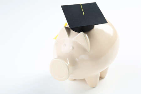 Piggybank in graduation cap on white backgroundの写真素材