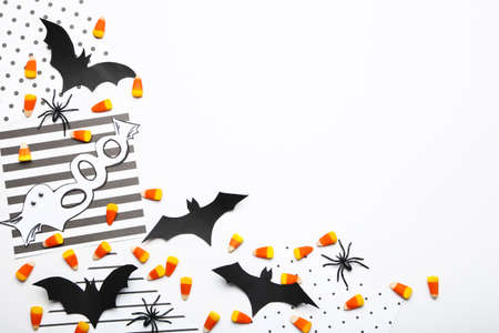 Halloween paper bats with candies and spiders on white backgroundの写真素材