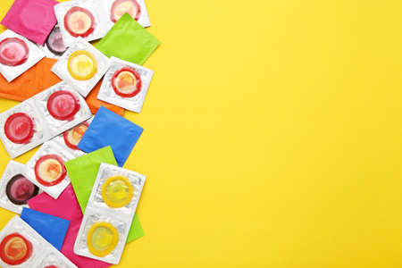 Colorful condoms on yellow backgroundの写真素材